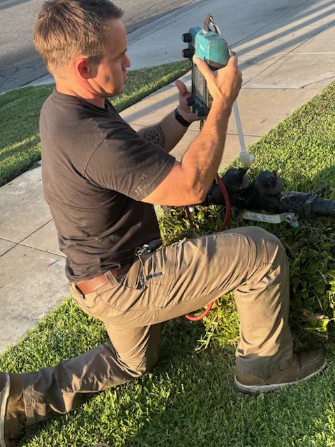 Certified technician testing a backflow prevention assembly with a calibrated test kit