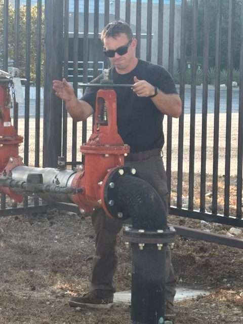 Technician servicing a fire service backflow prevention assembly