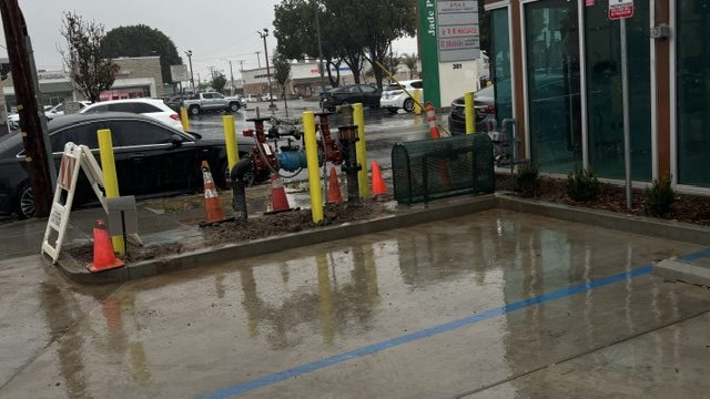 Bollards and fresh concrete pad protecting utility equipment in a parking lot