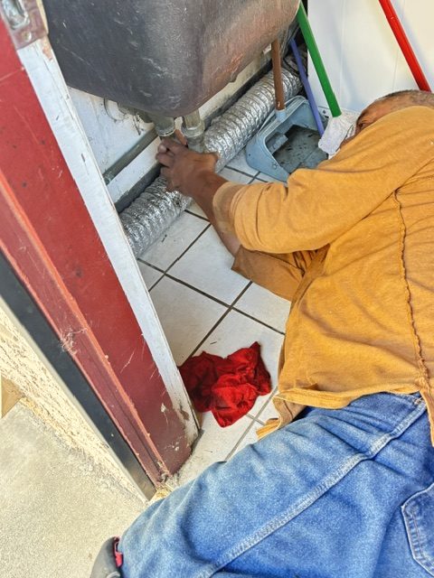 Plumber replacing a supply line inside a residential property
